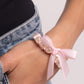 <p>Paparazzi Accessories - Ribbon Rarity - Pink Pearl Bracelets delicately wrapped in the folds of a baby pink ribbon, gleaming white pearls are infused along an elastic stretchy band around the wrist for a feminine, girly statement.</p> <p><i>Sold as one individual bracelet.</i></p>
