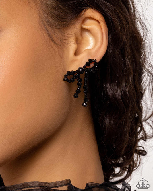 <p>Paparazzi Accessories - The BOW Must Go On - Black Earrings high-sheen black beads in various sizes and black seed beads loop and curl into an elegant, classic bow for a refined centerpiece. Earring attaches to a standard post fitting.</p> <p><i>Sold as one pair of post earrings.</i></p>