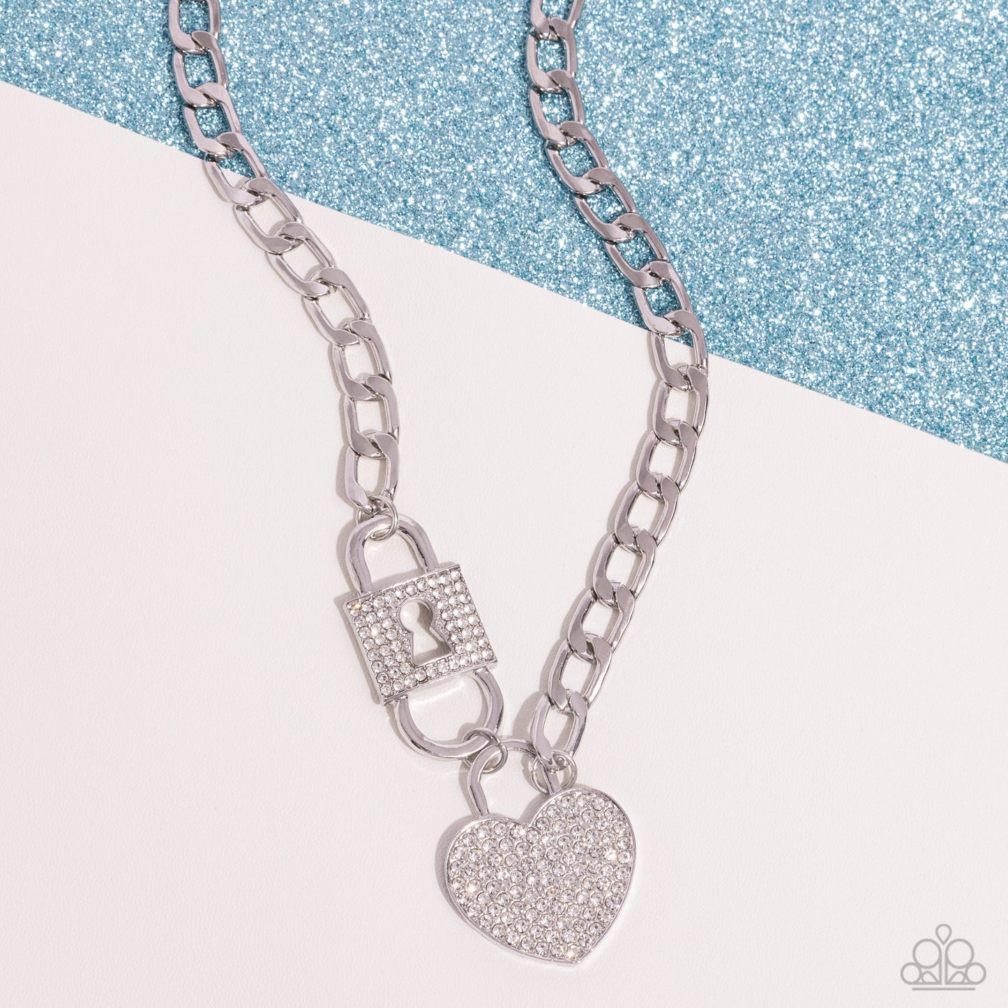 Embellished with glistening white rhinestones, a silver lock pendant and heart padlock interconnect from a silver curb chain for a romantic-inspired display of shimmer. Features an adjustable clasp closure.  Sold as one individual necklace. Includes one pair of matching earrings.