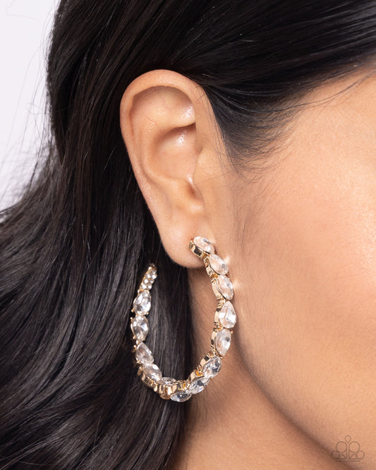 Paparazzi Accessories - Presidential Pizazz - Gold Hoop Earrings the front of a bold gold hoop is encrusted in glittery white rhinestones, creating a glamorous pop of sparkle. Earring attaches to a standard post fitting. Hoop measures approximately 2" in diameter.  Sold as one pair of hoop earrings.