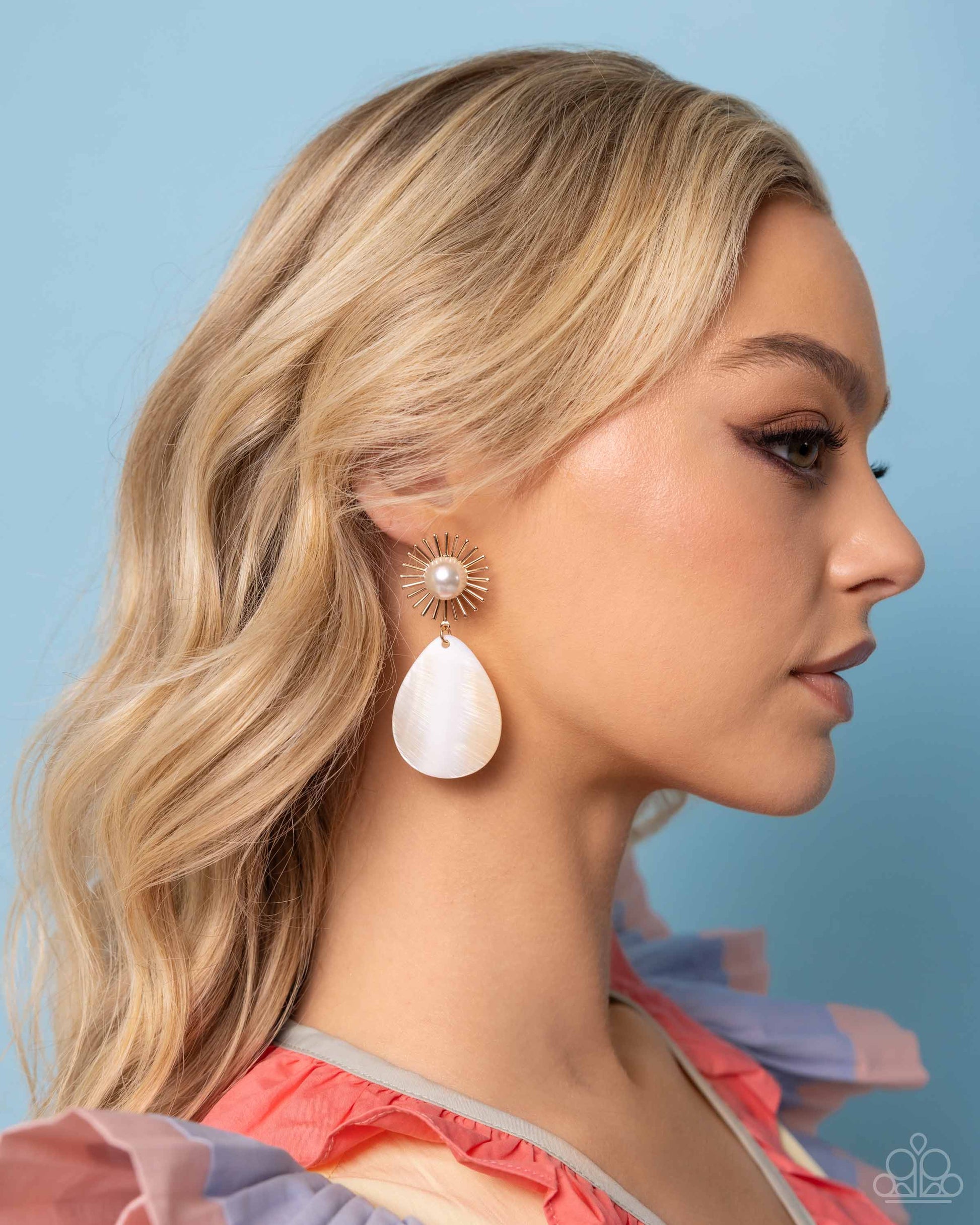 <p data-mce-fragment="1">Paparazzi Accessories - Sunburst Sophistication - Gold Earrings a gold sunburst shape dotted with a white pearl center gives way to a teardrop white shell resulting in a whimsically radiant lure. Earring attaches to a standard post fitting.</p> <p data-mce-fragment="1"><i data-mce-fragment="1">Sold as one pair of post earrings.</i></p>