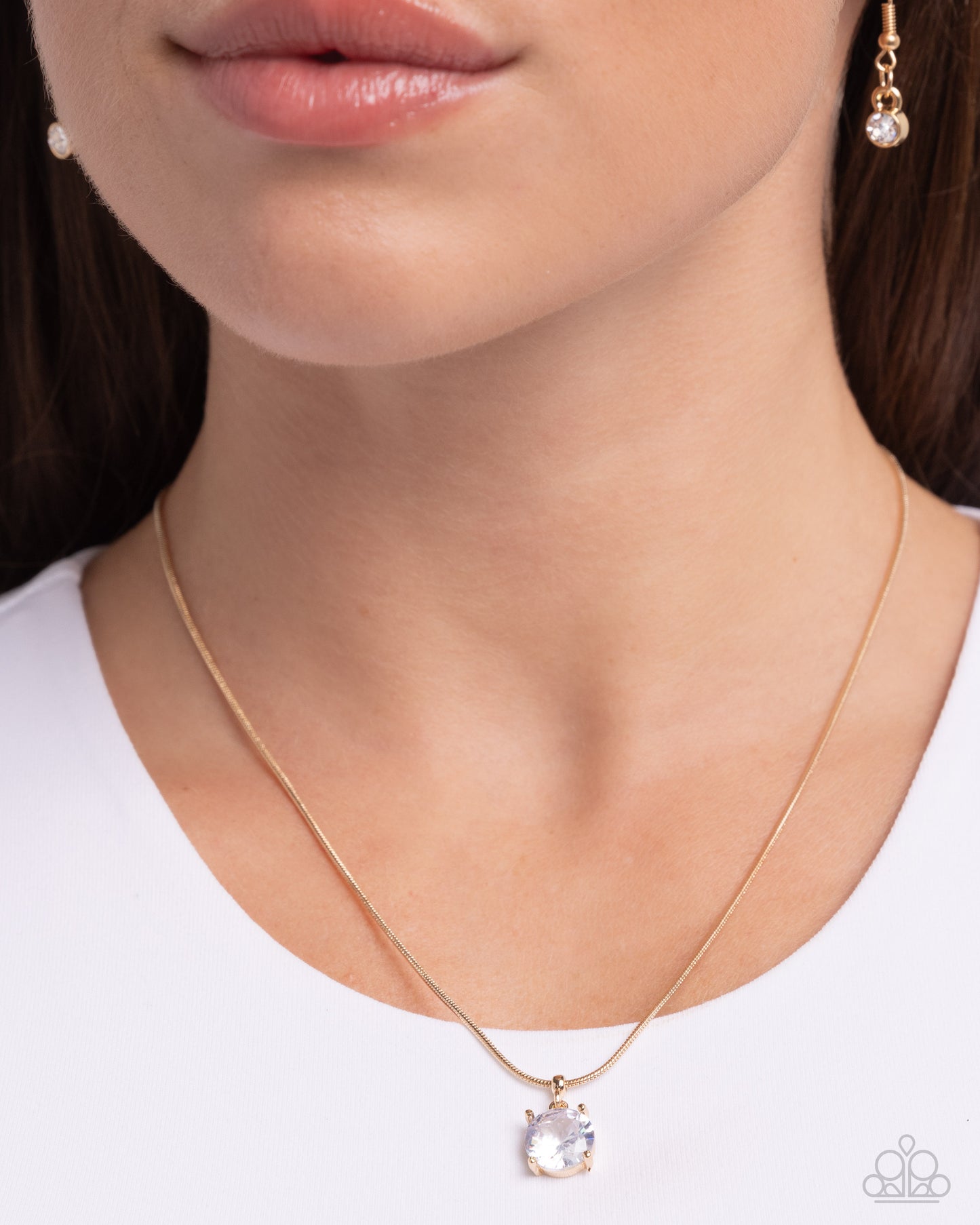 Set in pronged gold fittings, a faceted, glittery white gem glides along a gold snake chain for a beautiful basic. Features an adjustable clasp closure.  Sold as one individual necklace. Includes one pair of matching earrings.