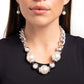 Oversized, high-sheen silver curb chain links gives way to a collection of oversized white pearls, silver beads, and white rhinestone-encrusted silver rings for a glamorously glossy look. Features an adjustable clasp closure.  Sold as one individual necklace. Includes one pair of matching earrings.