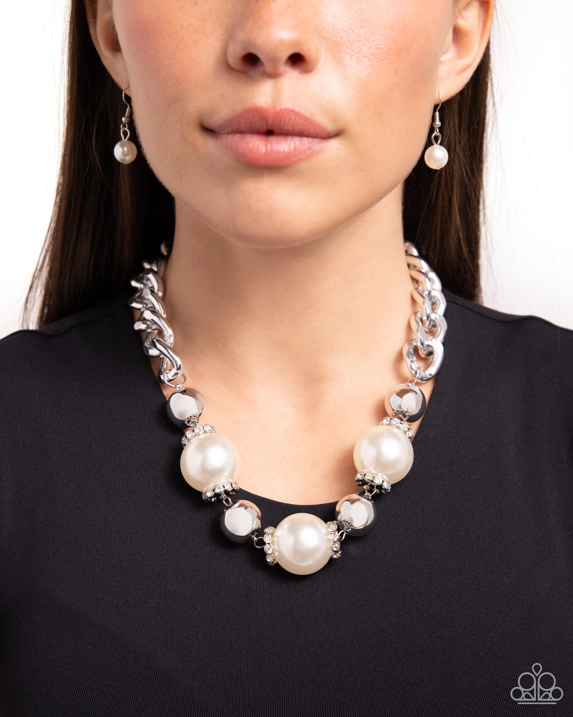 Oversized, high-sheen silver curb chain links gives way to a collection of oversized white pearls, silver beads, and white rhinestone-encrusted silver rings for a glamorously glossy look. Features an adjustable clasp closure.  Sold as one individual necklace. Includes one pair of matching earrings.