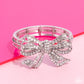 Paparazzi Accessories - It's All A-Bow-t Me - White Bracelets&nbsp;Infused along elastic stretchy bands, airy silver frames gleam along the wrist for a monochromatic display. Encrusted in white rhinestones, an oversized, airy silver bow glitters at the center of the design for a touch of class and refinement.  Sold as one individual bracelet.