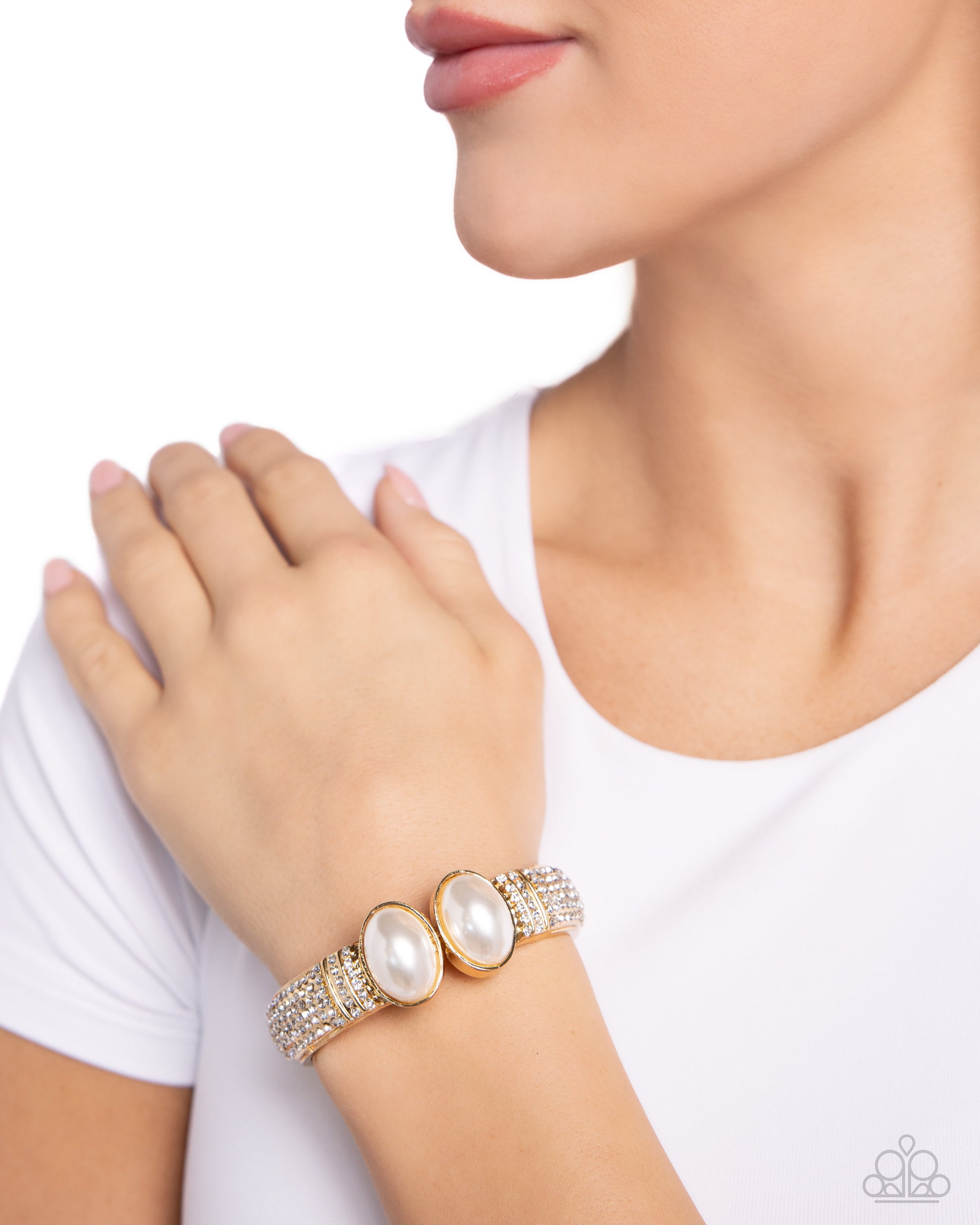 Featuring oversized white pearls, two shiny gold bars embellished with row after row of white rhinestones attach to a spring-like fitting as they curl around the wrist for a refined finish. Features a hinged closure.  Sold as one individual bracelet.