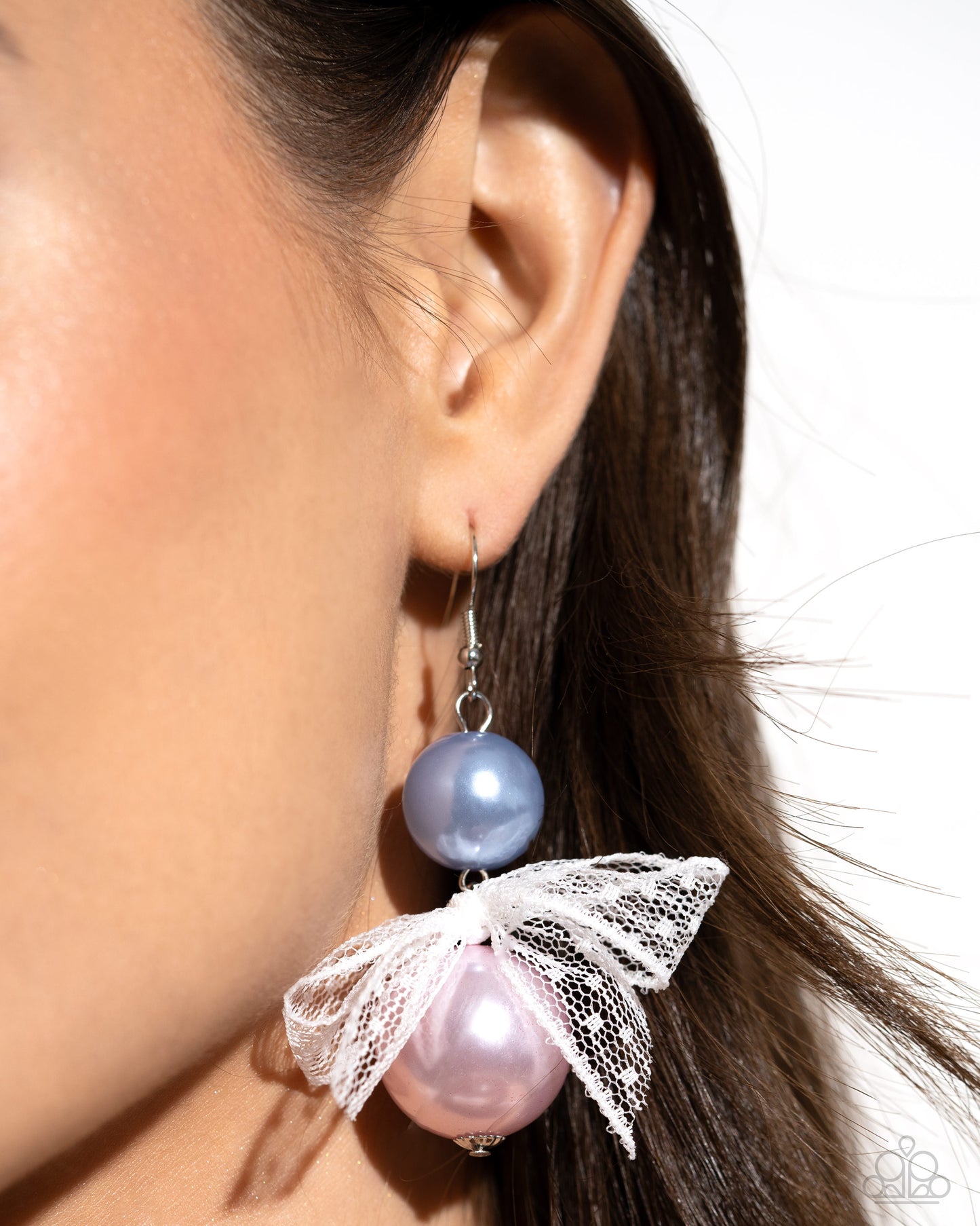 <p data-mce-fragment="1">Two glossy pearls one in blue and one in pink stack atop one another while an airy, chiffon white ribbon is tied in the center of the pearls for a refined finish. Earring attaches to a standard fishhook fitting.</p> <p data-mce-fragment="1"><i data-mce-fragment="1">Sold as one pair of earrings.</i></p>