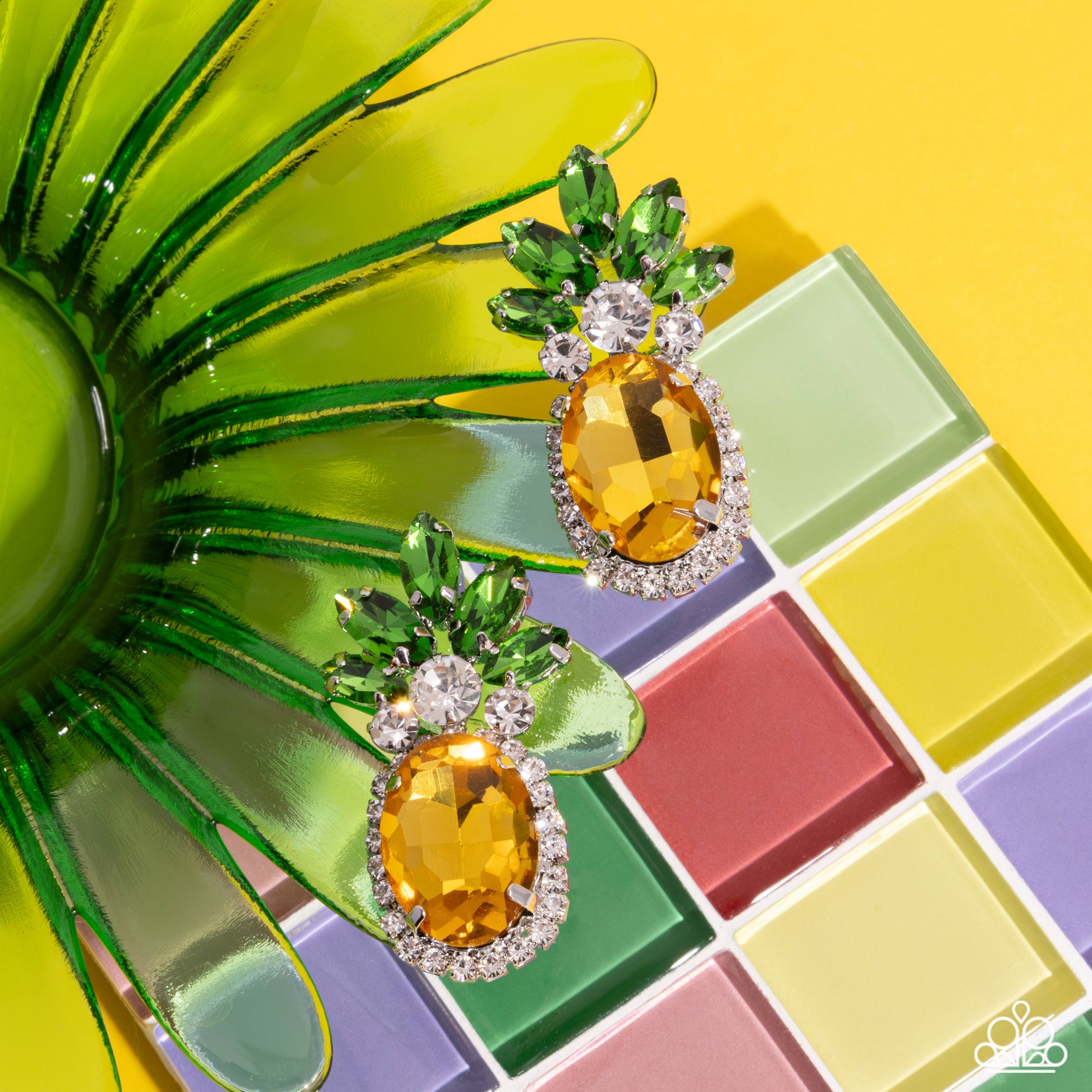 Featuring a pineapple motif, a collection of green marquise-cut faceted gems, white gems, dainty white rhinestones, and silver-pronged yellow oval gems creates a summery statement at the ear. Earring attaches to a standard post fitting.  Sold as one pair of post earrings.