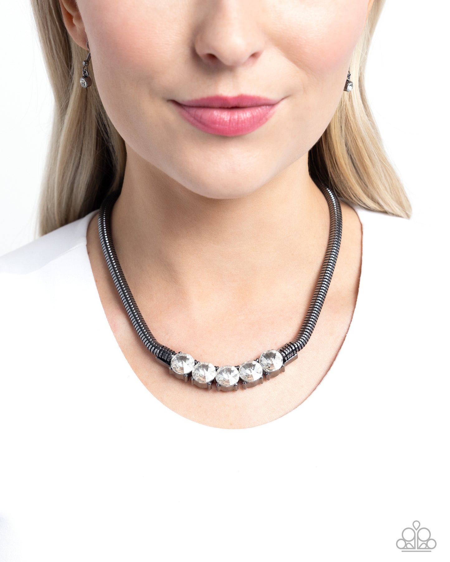 <p data-mce-fragment="1">Paparazzi Accessories - Musings Makeover - Black Necklachaipronged in place along the center of a thick gunmetal chain, faceted white gems twinkle below the neckline for a glittery, grungy look. Features an adjustable clasp closure.</p> <p data-mce-fragment="1"><i data-mce-fragment="1">Sold as one individual necklace. Includes one pair of matching earrings.</i></p>