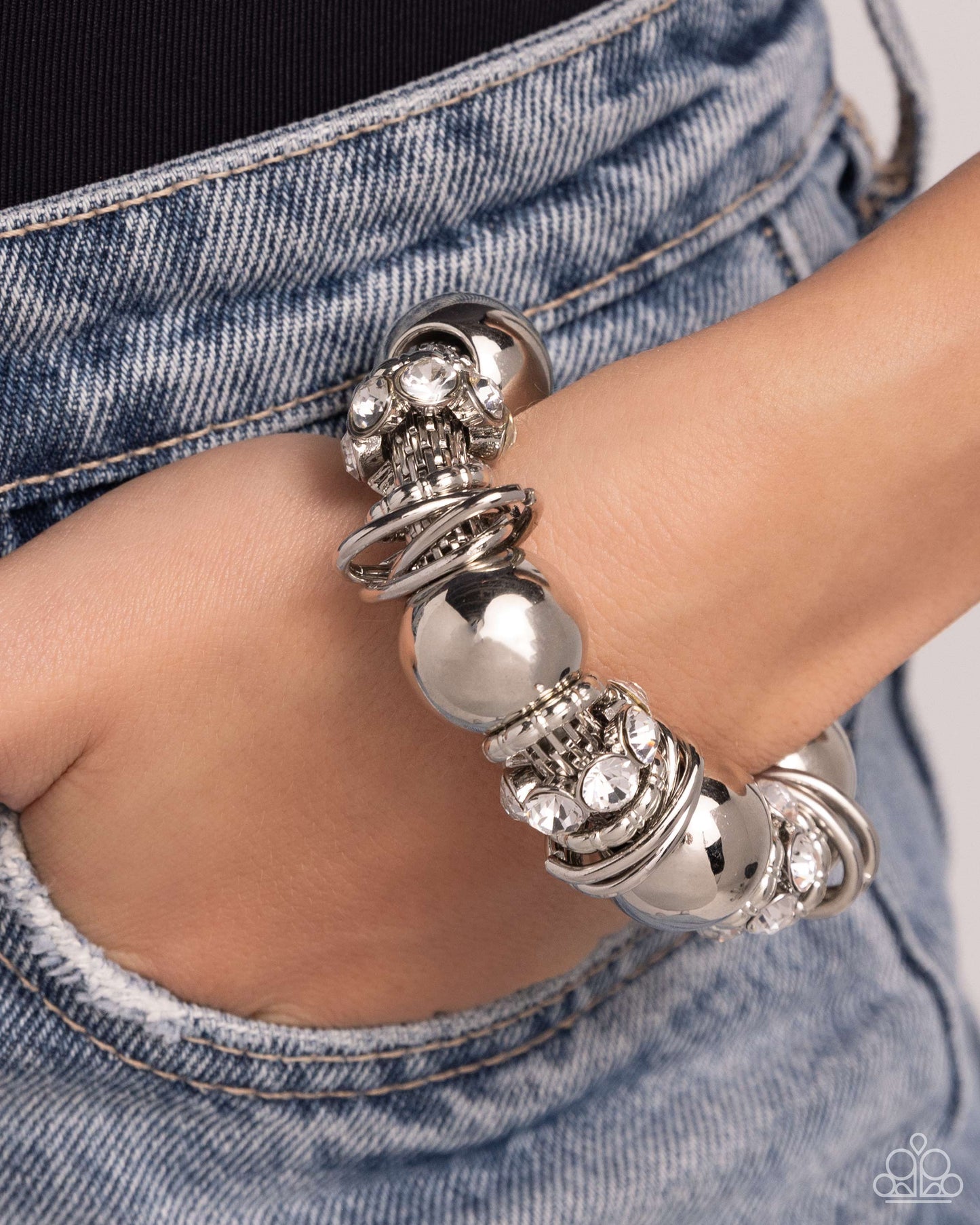 Paparazzi Accessories - Coiled Confidence - Silver Bracelets infused along an industrial abstract stretchy chain, a collection of interlocking silver rings, oversized silver beads, and white gem-encrusted silver accents twists and coils along the wrist for a charismatically confident look.  Sold as one individual bracelet.