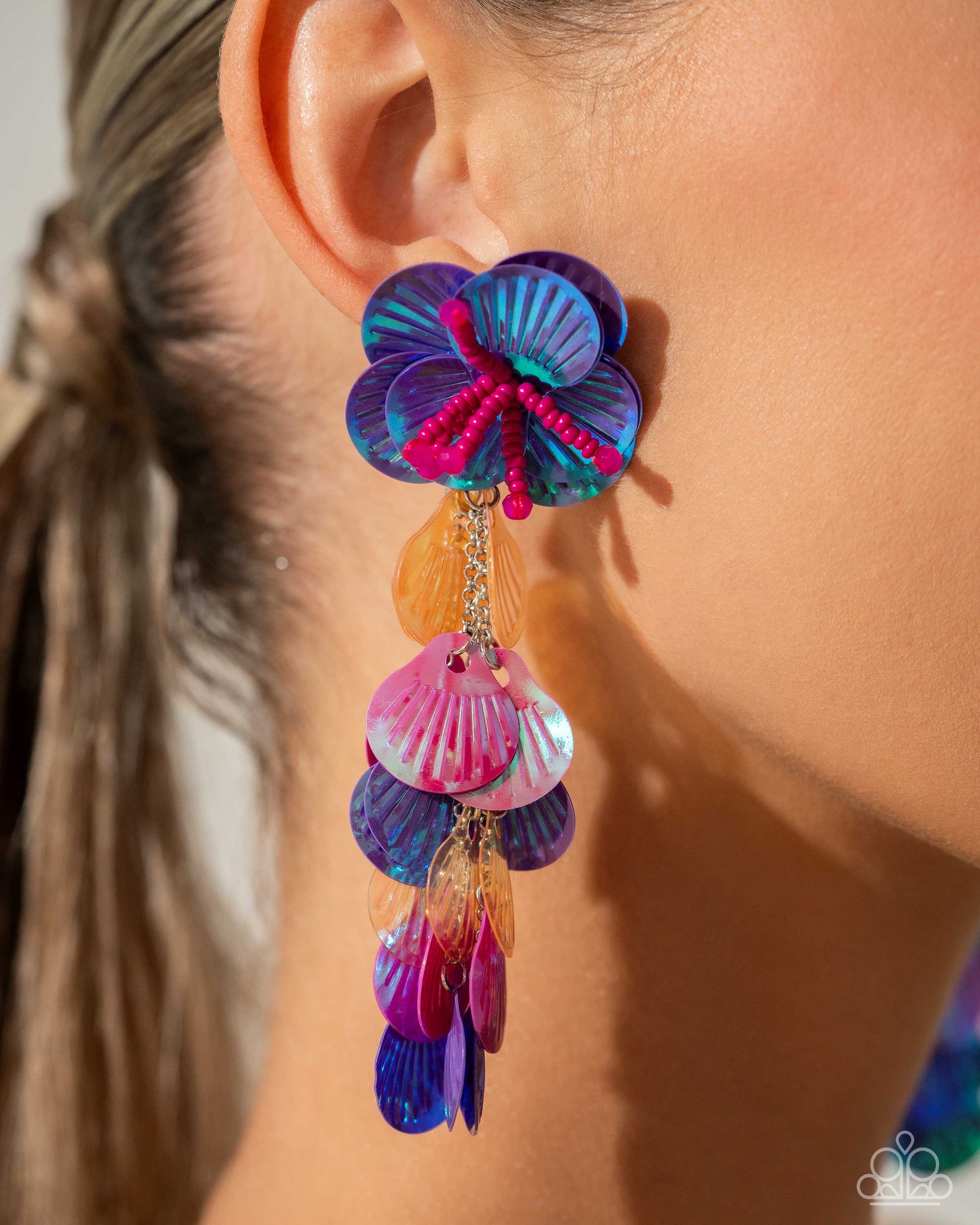 Featuring an iridescent hue, a collection of purple, pink, and orange sequins cascade from a collection of purple sequins that flourish from a hot pink seed beaded starfish for a coastal, chic look. Earring attaches to a standard post fitting. Due to its prismatic palette, color may vary.  Sold as one pair of post earrings.