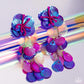 Featuring an iridescent hue, a collection of purple, pink, and orange sequins cascade from a collection of purple sequins that flourish from a hot pink seed beaded starfish for a coastal, chic look. Earring attaches to a standard post fitting. Due to its prismatic palette, color may vary.  Sold as one pair of post earrings.