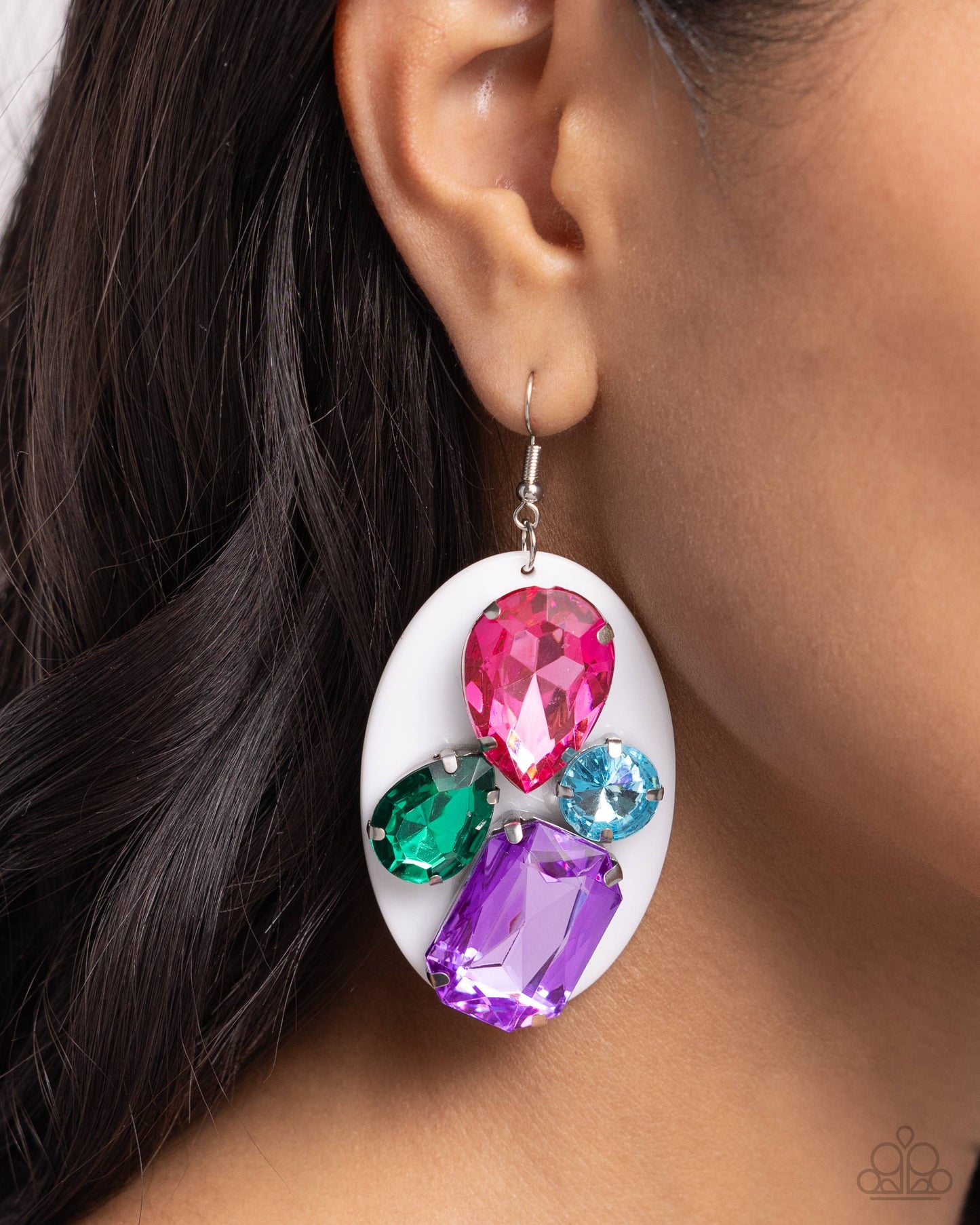 Pronged in place along a white acrylic oval in silver, multicolored faceted gems in varying sizes and teardrop, round, and emerald cuts cascades below the ear for an attention-grabbing display. Earring attaches to a standard fishhook fitting.  Sold as one pair of earrings.