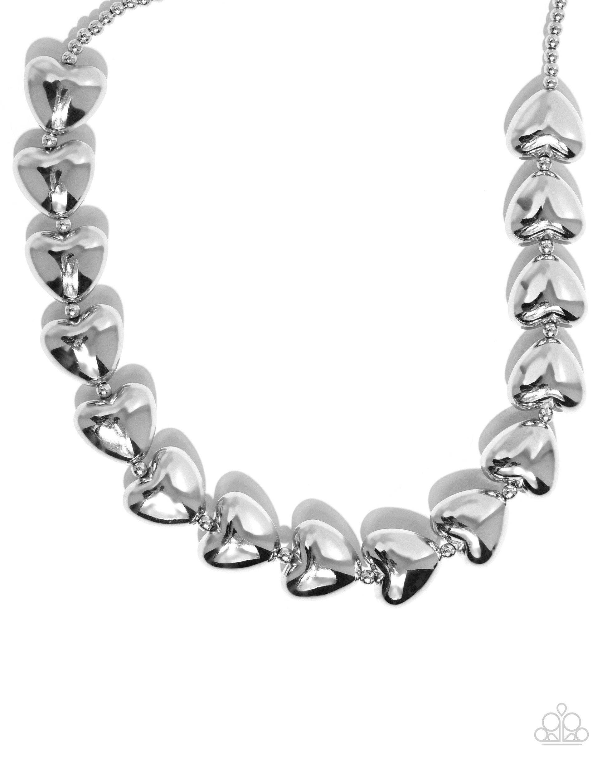 Infused along a classic silver chain, sleek silver hearts alternate with dainty silver beads along the neckline for a romantically refined statement. Features an adjustable clasp closure.  Sold as one individual necklace. Includes one pair of matching earrings.