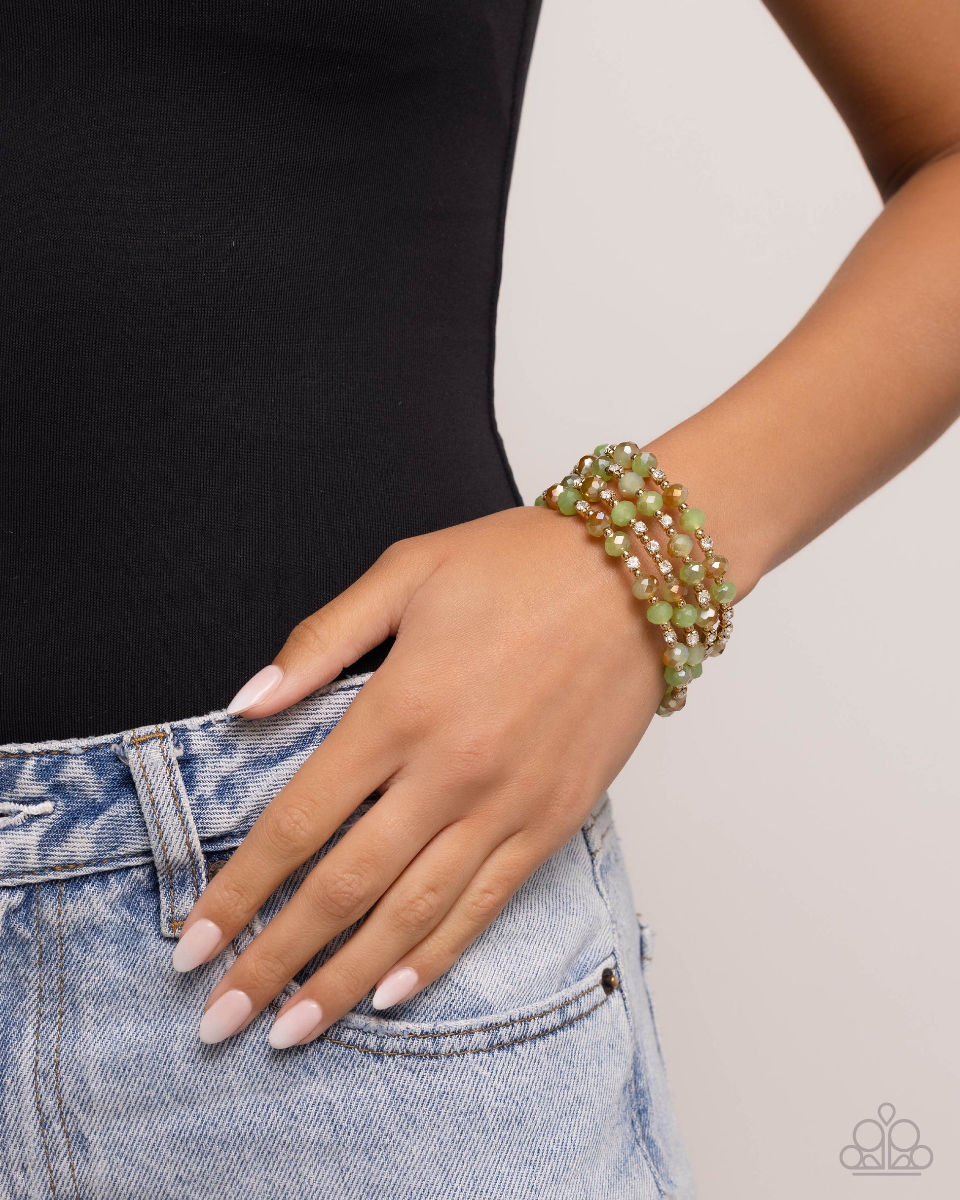 Brushed in a UV coating, reflective faceted green beads, green beads, gold beads, and white rhinestones in square fittings are threaded along a coiled wire, creating a refined infinity wrap-style bracelet around the wrist.  Sold as one individual bracelet.