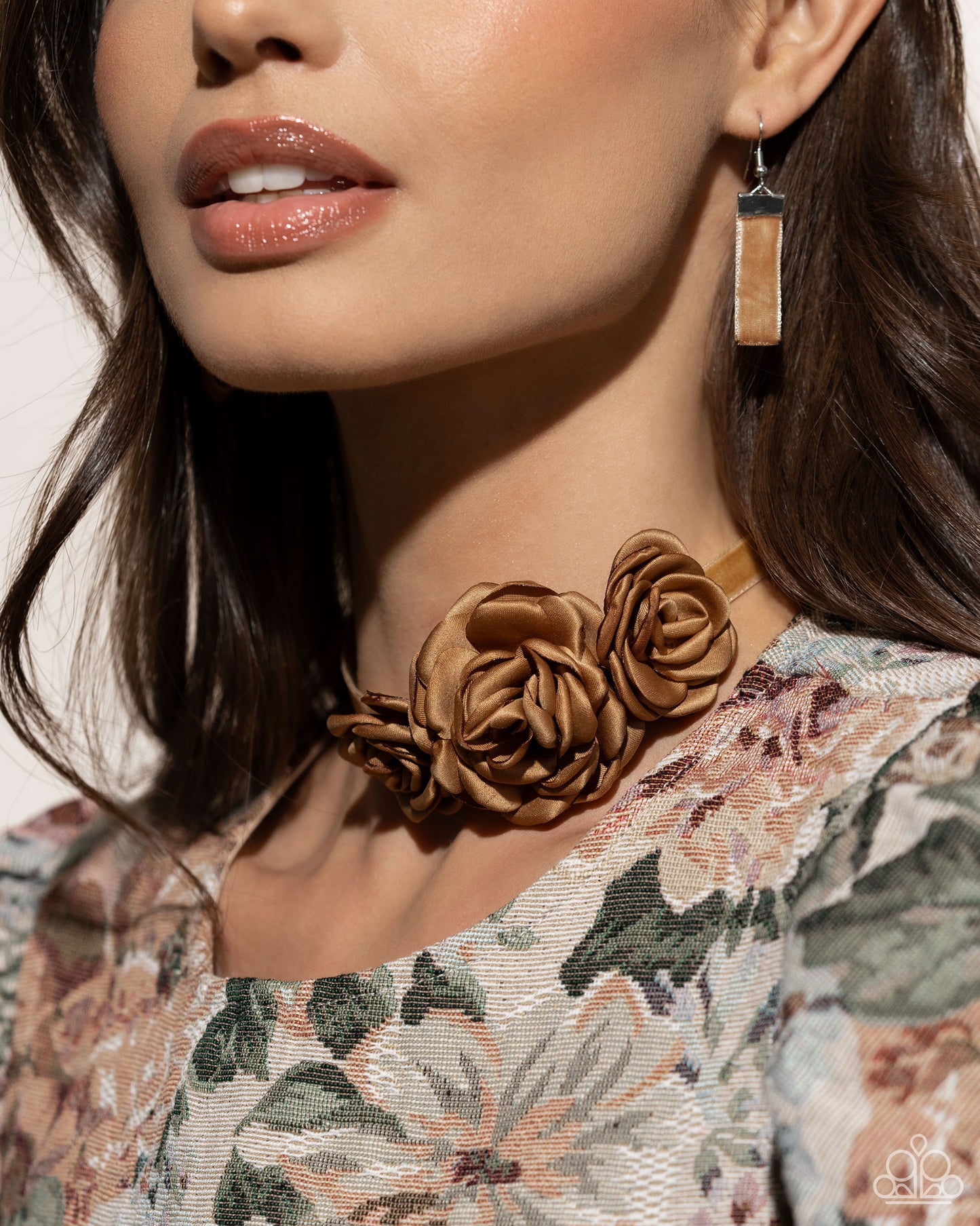 Light brown satin petals form into a decadent trio of rosettes atop a sleek satin ribbon in the same hue along the collar for a whimsical display. Features an adjustable clasp closure.  Sold as one individual choker necklace. Includes one pair of matching earrings.