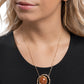 Suspended along the center of an oversized, warped, hammered gold hoop, a goldstone pendant, pressed in a smaller warped gold frame glides along a dainty gold chain for a glamorously gentle look. Features an adjustable clasp closure. As the stone elements in this piece are natural, some color variation is normal.  Sold as one individual necklace. Includes one pair of matching earrings.