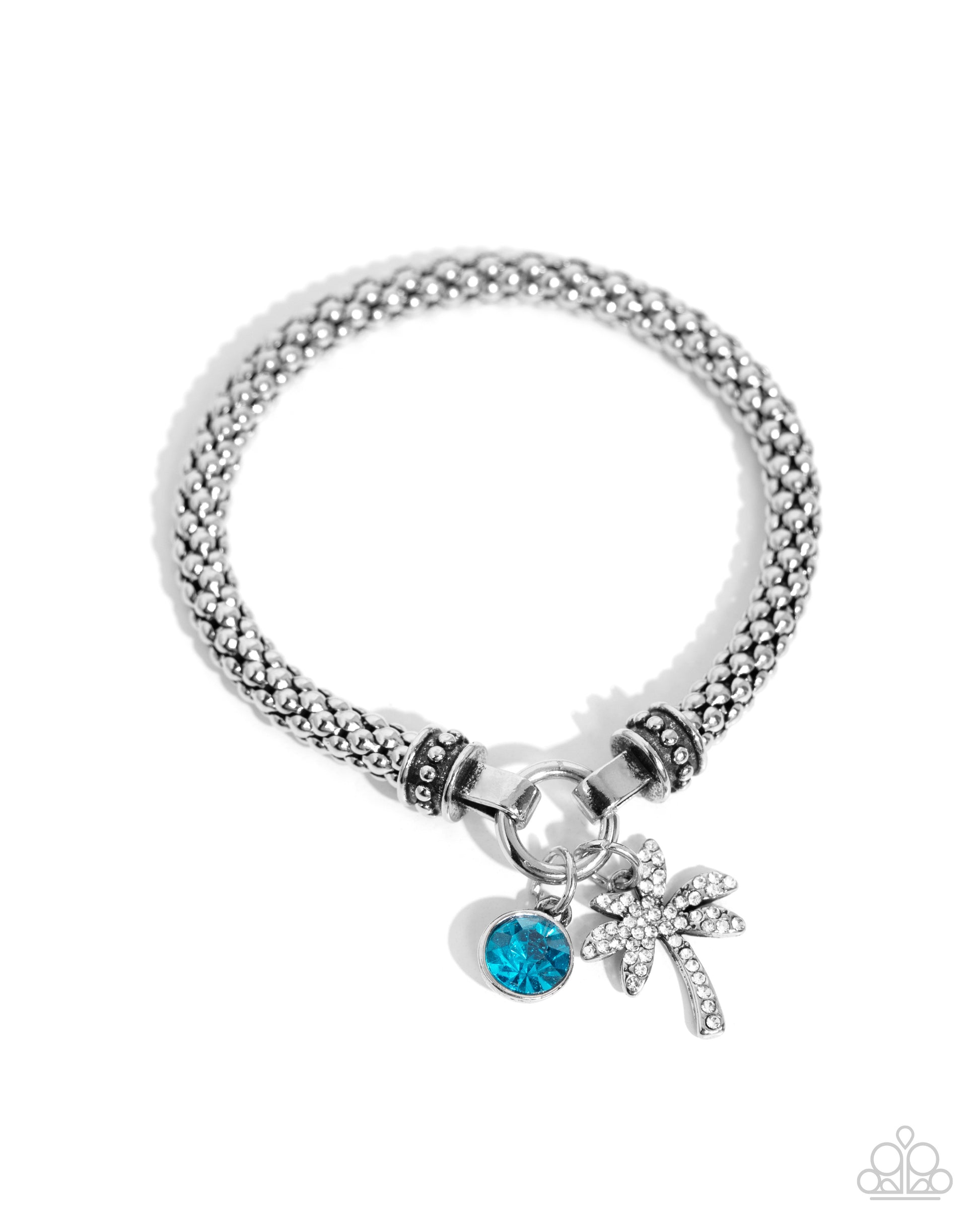 Featuring a high-sheen finish, a rounded silver mesh claw chain streams along the wrist from silver studded caps on a stretchy band. The meshed strand attaches to a silver ring at the center of the wrist where a white rhinestone-encrusted palm tree and solitaire blue zircon gem pressed in a silver fitting swing for a whimsical finish.  Sold as one individual bracelet.