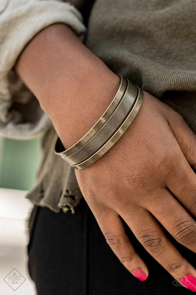 Featuring antiqued finishes and gritty linear patterns, a collection of brass bangles stacks across the wrist for a rustic look.  Sold as one set of three bracelets.