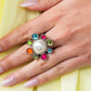 Pressed into a high-sheen silver frame, glassy and milky olive, Pink Peacock, turquoise, orange, and Kohlrabi petals encircle an abstract pearly center, creating an ethereal flower centerpiece atop the finger. Features a stretchy band for a flexible fit.  Sold as one individual ring.