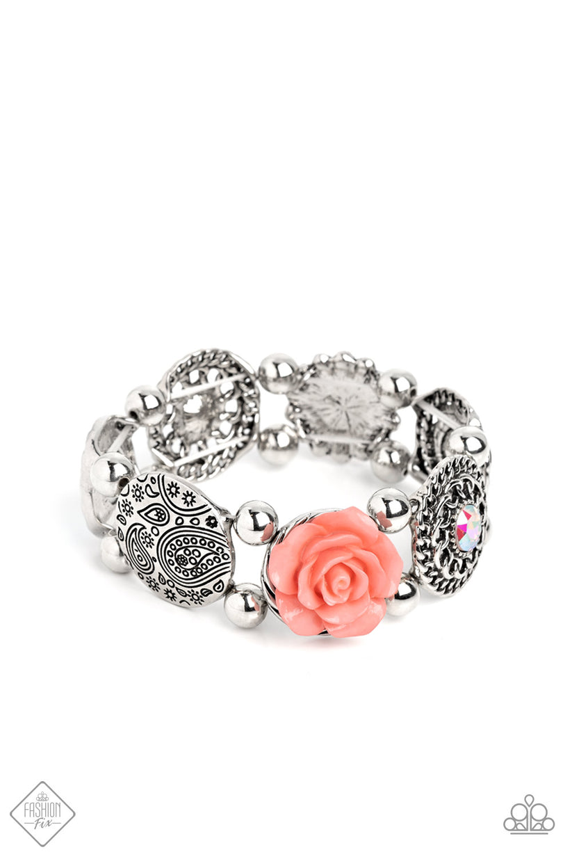 Whimsically woven around the wrist on elastic stretchy bands, a coral resin rose, a silver disc stamped with a paisley motif, an oversized iridescent gem with an orange undertone encased in a textured silver frame, an airy, textured wheel pendant with an iridescent center, a pearl-centered flower with Peach Pink gem petals, and a disc featuring a metallic rose, create a beautifully botanical design. Classic silver beads separate each element, allowing the details of each one to stand out