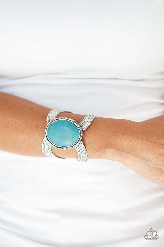 Coyote Couture - Blue Cuff Bracelet a dramatic turquoise stone pendant is pressed into the center of textured silver bars, creating a bold seasonal cuff. Sold as one individual bracelet.