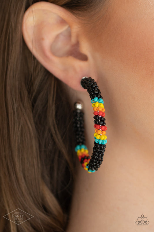 Paparazzi Accessories Bodaciously Beaded - Black Seedbead Hoop Earrings aolorful strand of black, blue, yellow, orange, and red seed beads wraps around a shiny silver hoop, creating a colorfully seasonal look. Earring attaches to a standard post fitting. Hoop measures approximately 2" in diameter.  Sold as one pair of hoop earrings.  Paparazzi Jewelry is lead and nickel free so it's perfect for sensitive skin too!