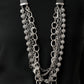 The Arlingto 2020 Zi Collection Necklaces attached to two strips of black leather, strands of bedazzled white rhinestone encrusted silver beads drape between an exaggerated display of mismatched silver and gunmetal chains down the chest. With its edgy sparkle, grunge meets glamour in this heart-stopping statement-maker. Features an adjustable clasp closure. Sold as one individual necklace. Includes one pair of matching earrings.