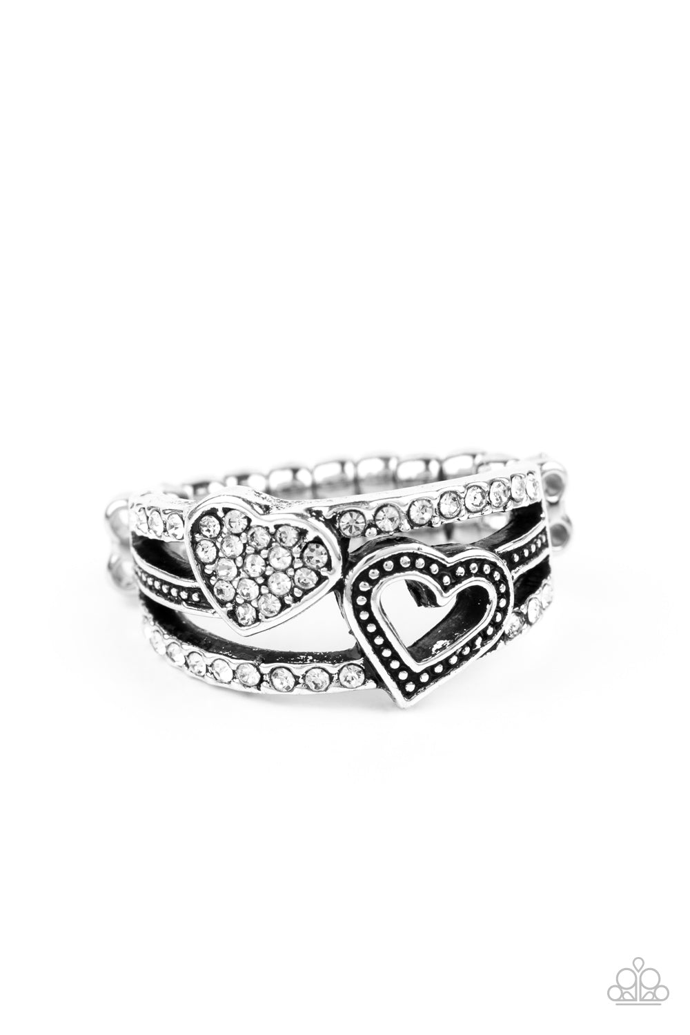 Paparazzi Accessories You Make My Heart BLING - White Rings two rows of white rhinestone encrusted bands flank a dainty silver band dotted in antiqued studs across the finger. A white rhinestone encrusted heart and studded silver heart overlap the layered bands, creating a colorfully charming centerpiece. Features a dainty stretchy band for a flexible fit.
