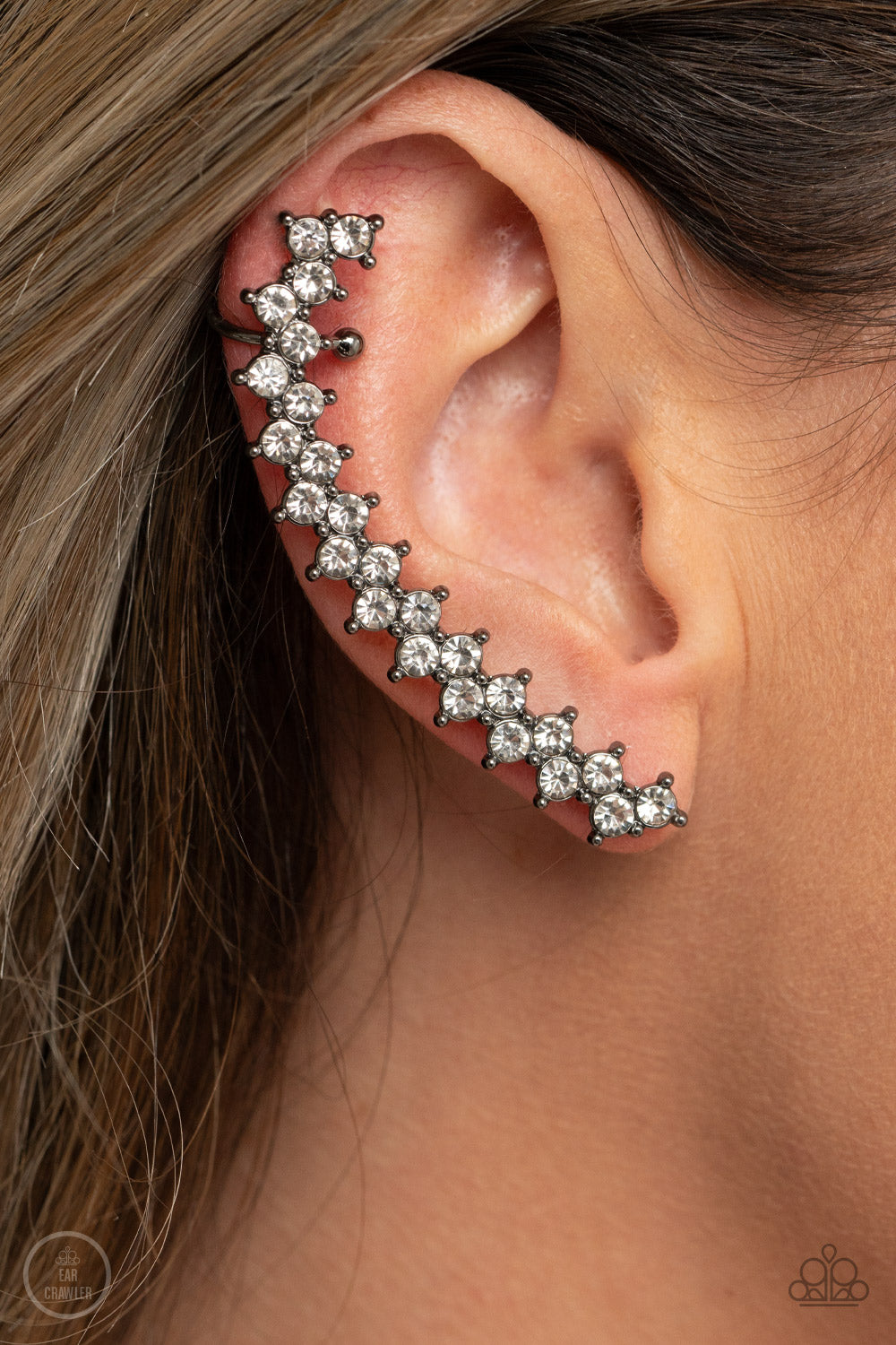 Let There Be LIGHTNING - Black Rhinestone Ear Crawlers encased in studded gunmetal fittings, pairs of glassy white rhinestones stack into a zigzagging frame up the ear for an electrifying fashion. Features a dainty cuff attached to the top for a secure fit.  Sold as one pair of ear crawlers.  Paparazzi Jewelry is lead and nickel free so it's perfect for sensitive skin too!
