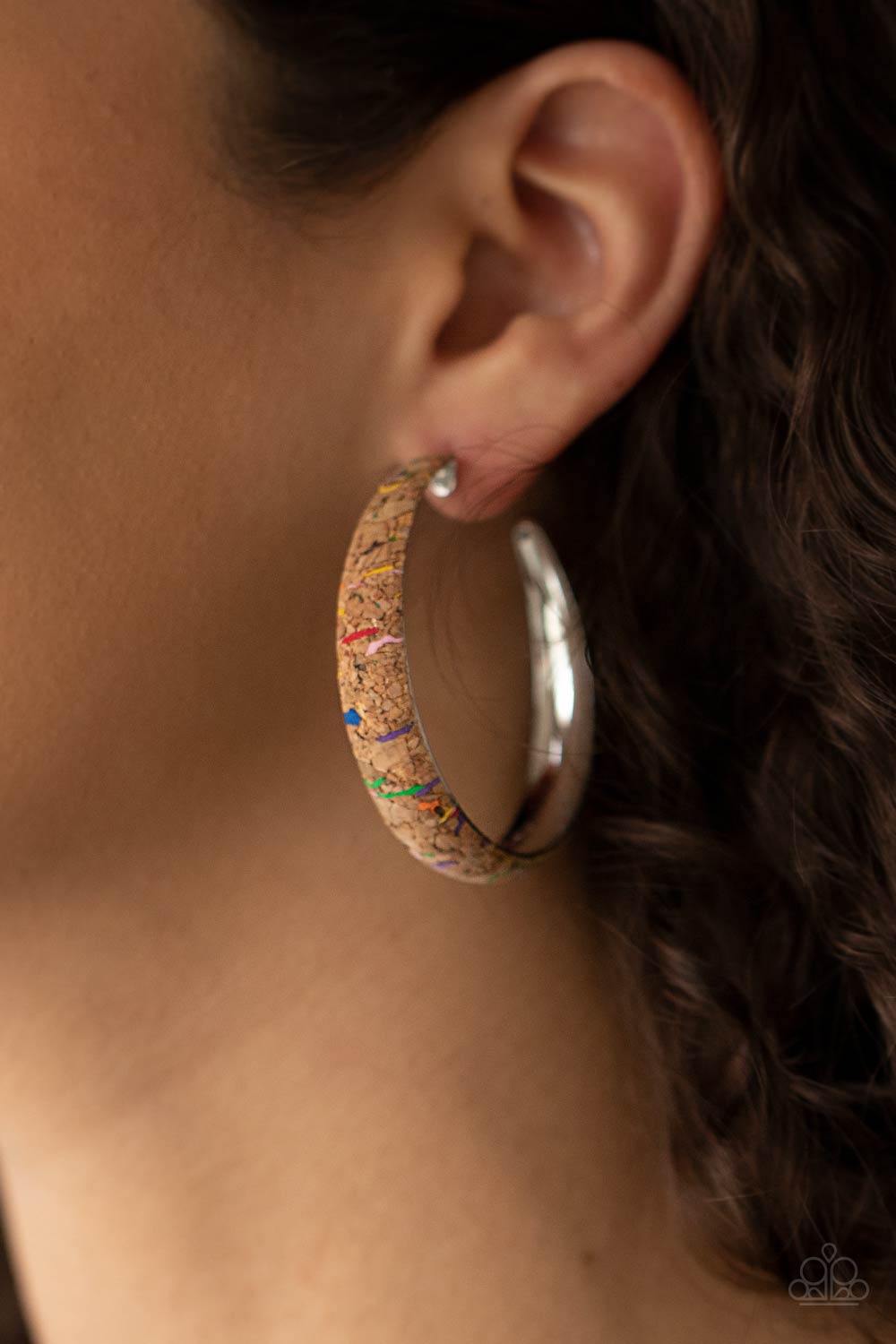 A Cork in the Road - Multi Hoop Earrings a cork lined silver hoop is splattered in multicolored paint, creating a colorful display. Hoop measures approximately 2" in diameter. Earring attaches to a standard post fitting.  Sold as one pair of hoop earrings.