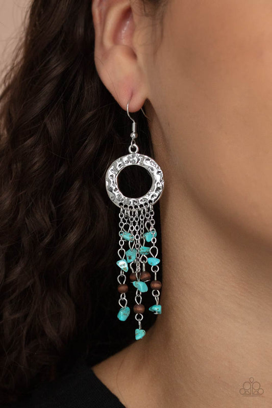 Paparazzi Accessories Primal Prestige - Blue Fishhook Earrings tapered tassels of dainty wooden beads and turquoise pebbles stream from the bottom of a hammered silver hoop, creating an earthy fringe. Earring attaches to a standard fishhook fitting.