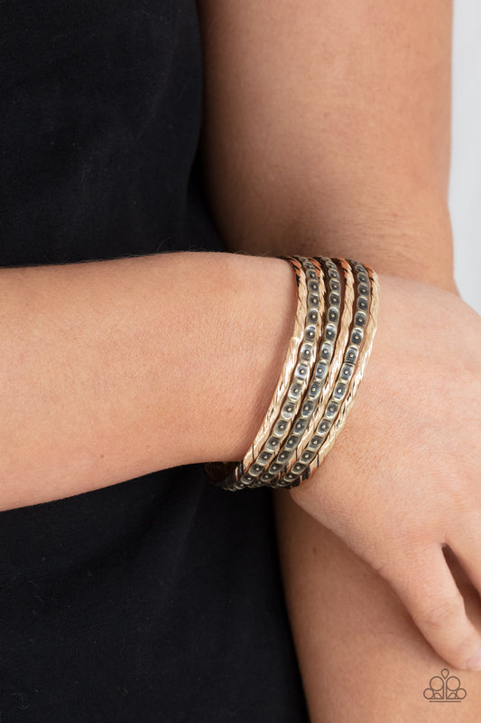 Paparazzi Accessories Back-To-Back Stacks - Multi Bracelets embossed in slanted ribbons of textured and studded hammered patterns, trios of mismatched brass and gold bangles stack across the wrist for an intense industrial vibe.  Sold as one set of six bracelets.