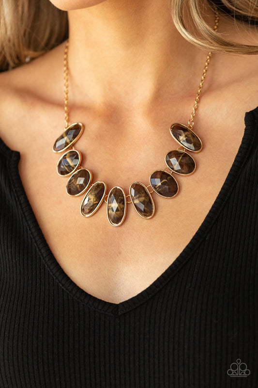 Elliptical Episode - Brown Glossy Gems Necklaces generous glossy brown gems, dusted in shimmery gold, lay in oval gold frames and link across the collar creating a glimmering statement. Features an adjustable clasp closure.  Sold as one individual necklace. Includes one pair of matching earrings.  Paparazzi Jewelry is lead and nickel free so it's perfect for sensitive skin too!