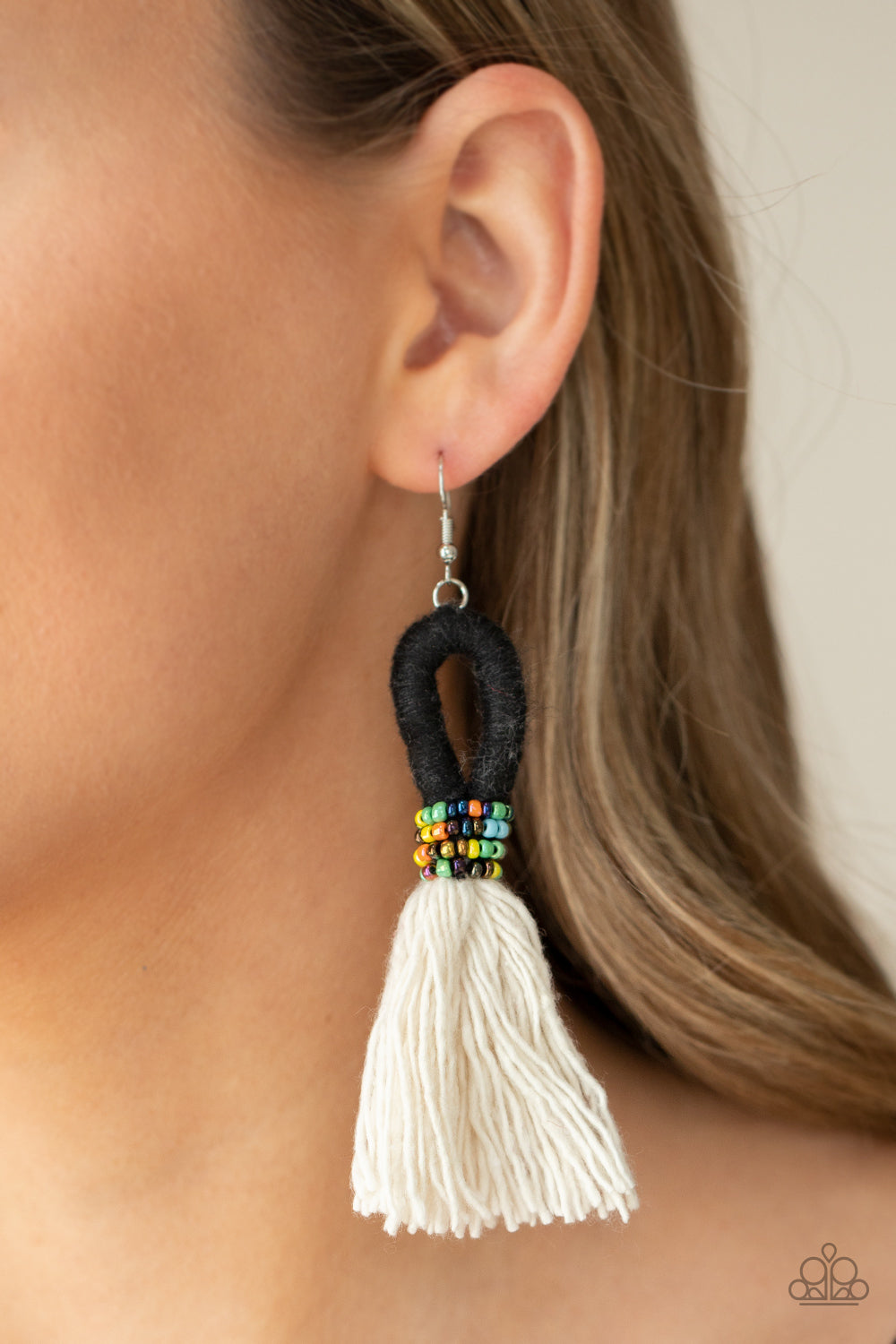 The Dustup - Black Earrings a tassel of soft white cotton fans out under rows of brightly colored seed beads. Anchored by a loop of jet black floss, the eye-catching style swings from the ear for a show-stopping statement. Earring attaches to a standard fishhook fitting.  Sold as one pair of earrings.  Paparazzi Jewelry is lead and nickel free so it's perfect for sensitive skin too!