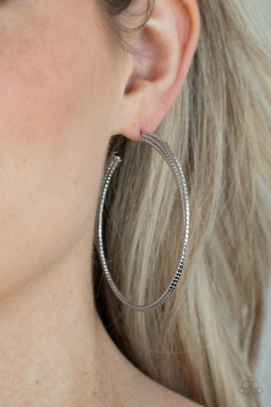 Candescent Curves - Silver Layered Hoops cut in tactile texture, three silver bars delicately stack and curve into a layered hoop for an edgy urban look. Earring attaches to a standard post fitting. Hoop measures approximately 2 1/2" in diameter.  Sold as one pair of hoop earrings.
