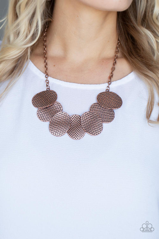 Industrial Wave - Copper Disc Necklaces a row of gently warped copper discs link together in an overlapping fashion as they connect on each end to a copper chain. Etched in a hammered antiqued copper finish, the oval discs create an edgy industrial effect below the collar. Features an adjustable clasp closure.  Sold as one individual necklace. Includes one pair of matching earrings.