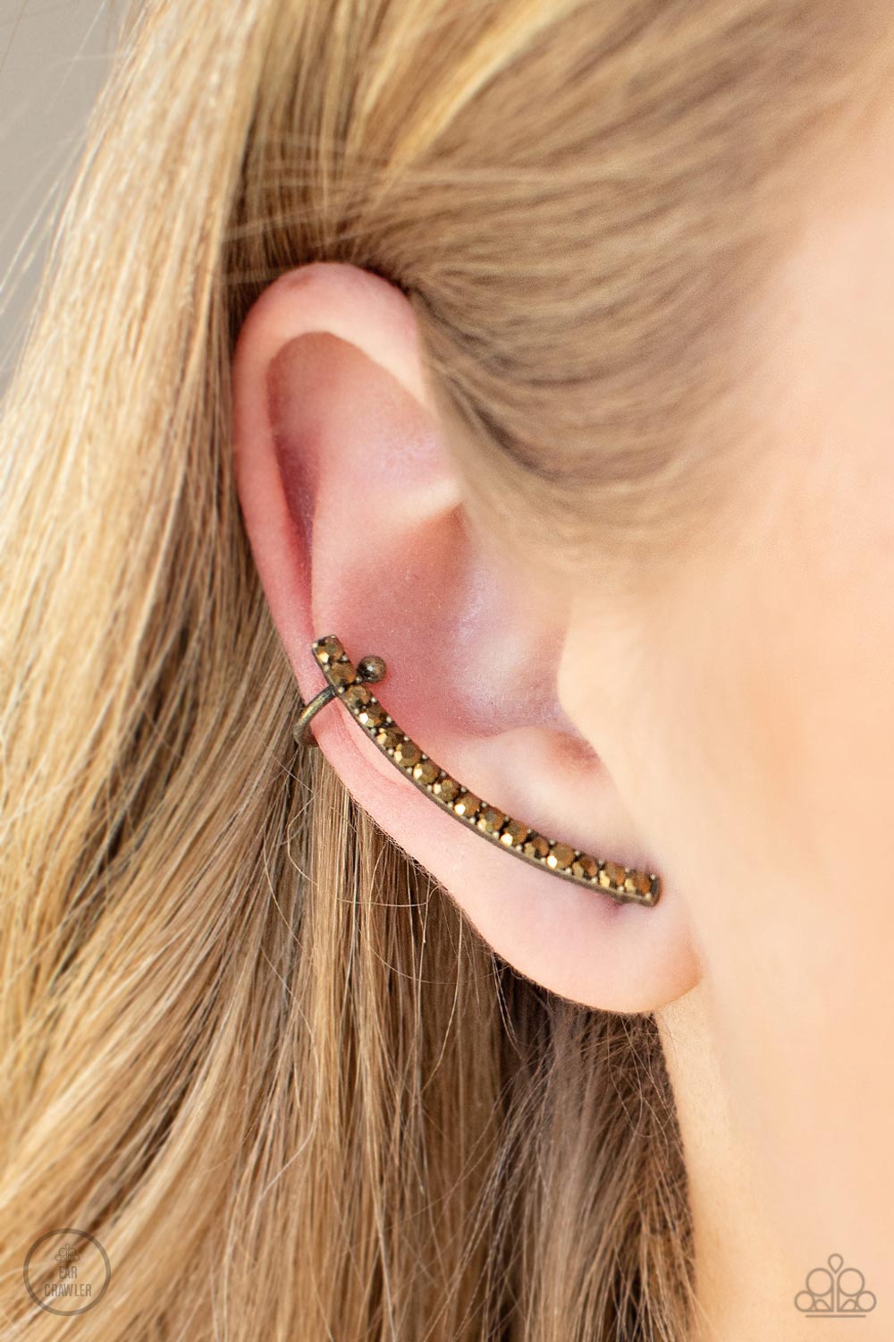 Give Me the SWOOP - Brass Aurum Rhinestone Crawler Post Earrings dainty row of glitzy aurum rhinestones is encrusted along a gritty brass bar that swoops up the ear for a smoldering style. Features a dainty cuff attached to the top for a secure fit.  Sold as one pair of ear crawlers.  Paparazzi Jewelry is lead and nickel free so it's perfect for sensitive skin too!
