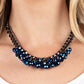 Galactic Knockout - Blue Beaded Necklaces faceted collection of metallic flecked blue beads cluster along the center of a chunky gunmetal curb chain, creating a stellar fringe below the collar. Features an adjustable clasp closure.  Sold as one individual necklace. Includes one pair of matching earrings.