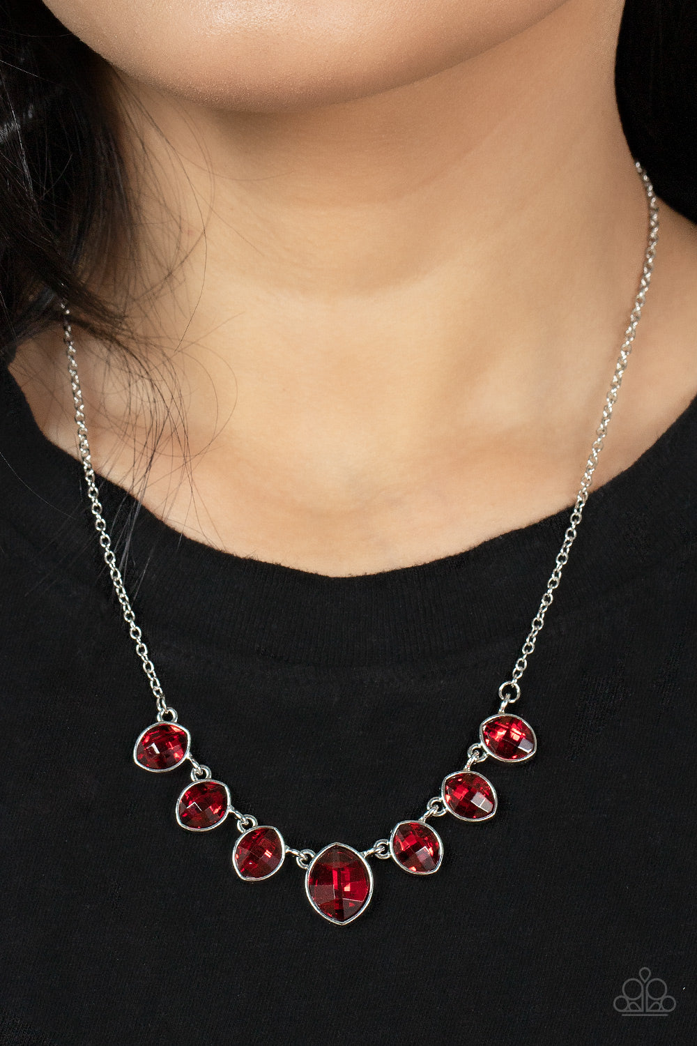 Material Girl Glamour - Red Necklaces encased in sleek silver fittings, elegant cut fiery red rhinestones delicately connect below the collar. An oversized red rhinestone adorns to the middle of the glittery strand, creating a sparkly centerpiece. Features an adjustable clasp closure.  Sold as one individual necklace. Includes one pair of matching earrings.  Paparazzi Jewelry is lead and nickel free so it's perfect for sensitive skin too!