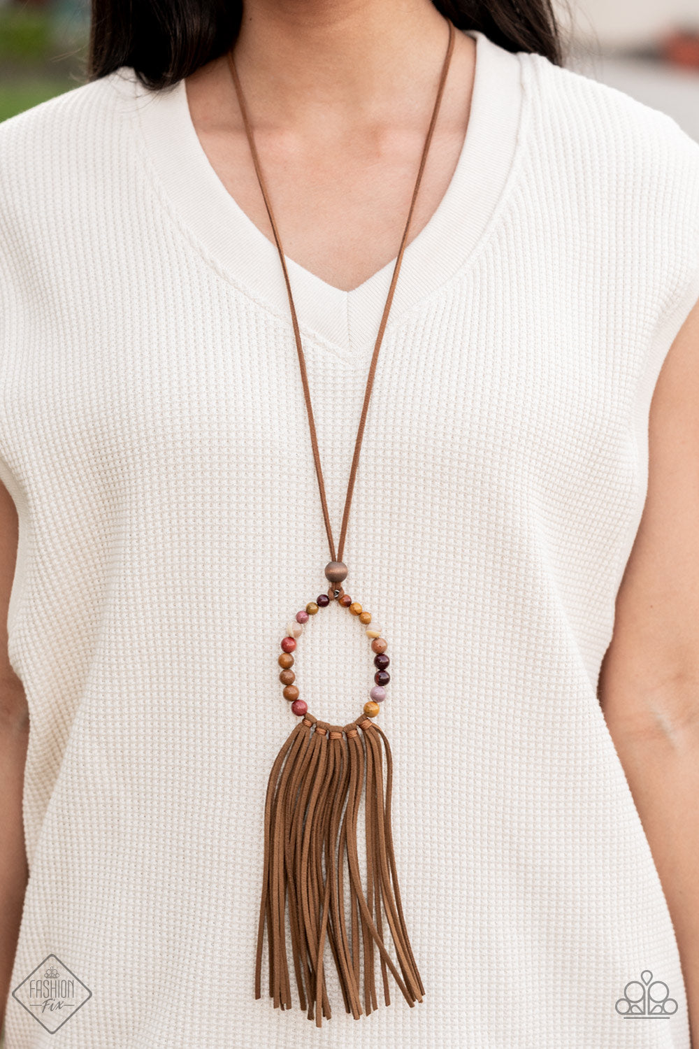Namaste Mama - Multi Stone Bead Necklaces - Paparazzi Accessories a collection of earthy multicolored stone beads are threaded around a wire hoop that is fastened at the end of a lengthened brown suede cord. The earthy stones make way for a foxy fringe of brown suede that sways from the bottom of the hoop, resulting in a rustic down-to-earth vibe. Features an adjustable clasp closure.