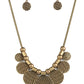 Indeginously Urban - Brass Disc Necklaces - Paparazzi Accessories Embossed in metallically stitched patterns, brass discs gradually increase in size as they alternate with chunky brass beads along a round brass snake chain, creating a noise-making fringe below the collar. Features an adjustable clasp closure. Sold as one individual necklace. Includes one pair of matching earrings.