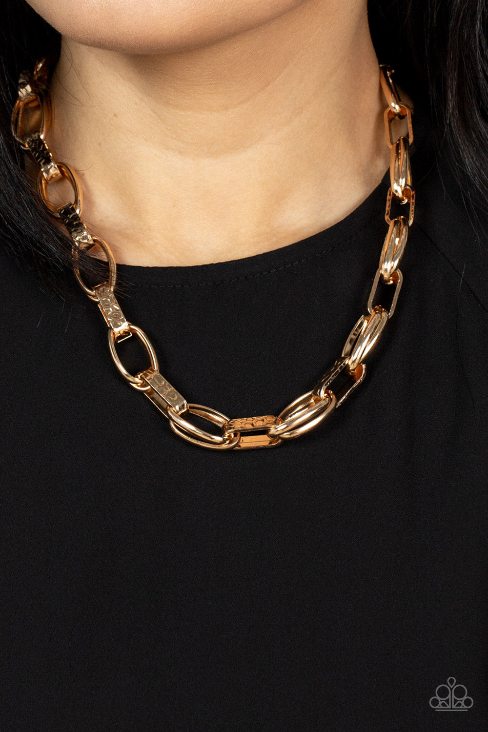 Motley in Motion - Gold Link Necklaces wide hammered gold links alternate with double sets of shiny gold links as they connect across the collar for an edgy industrial effect. Features an adjustable clasp closure.  Sold as one individual necklace. Includes one pair of matching earrings.