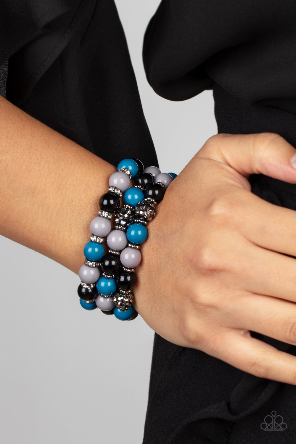 Paparazzi Accessories - Poshly Packing - Multi Bracelets a posh collection of polished multicolored beads, studded gunmetal rings, white rhinestone encrusted rings, and hematite dotted beads are threaded along stretchy bands around the wrist, creating sassy layers.  Sold as one set of three bracelets.