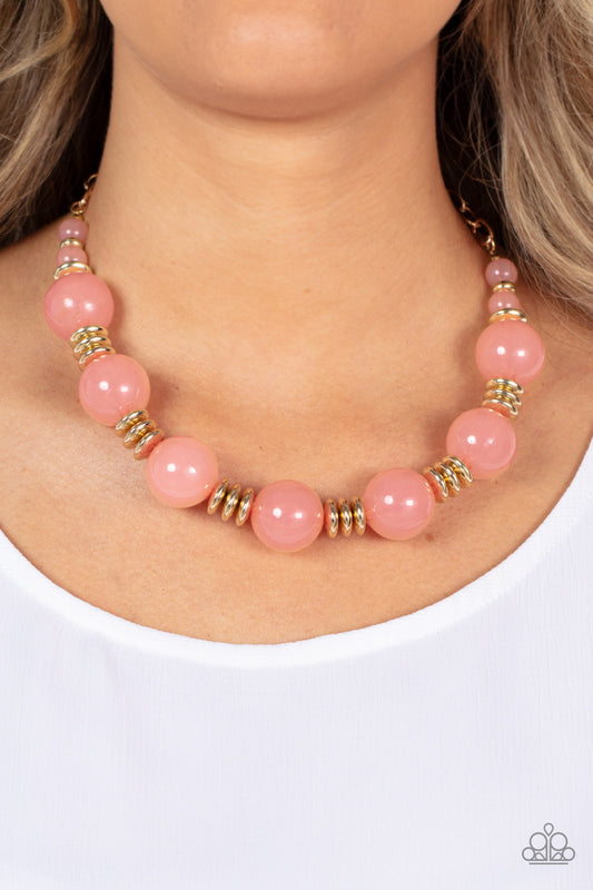 Paparazzi Accessories - Race to the Pop - Pink Necklaces an oversized collection of glassy Pale Rosette beads and shiny gold discs are threaded along an invisible wire, creating a dramatic pop of color below the collar. Features an adjustable clasp closure.  Sold as one individual necklace. Includes one pair of matching earrings.