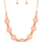 Paparazzi Accessories - Race to the Pop - Pink Necklaces an oversized collection of glassy Pale Rosette beads and shiny gold discs are threaded along an invisible wire, creating a dramatic pop of color below the collar. Features an adjustable clasp closure.  Sold as one individual necklace. Includes one pair of matching earrings.
