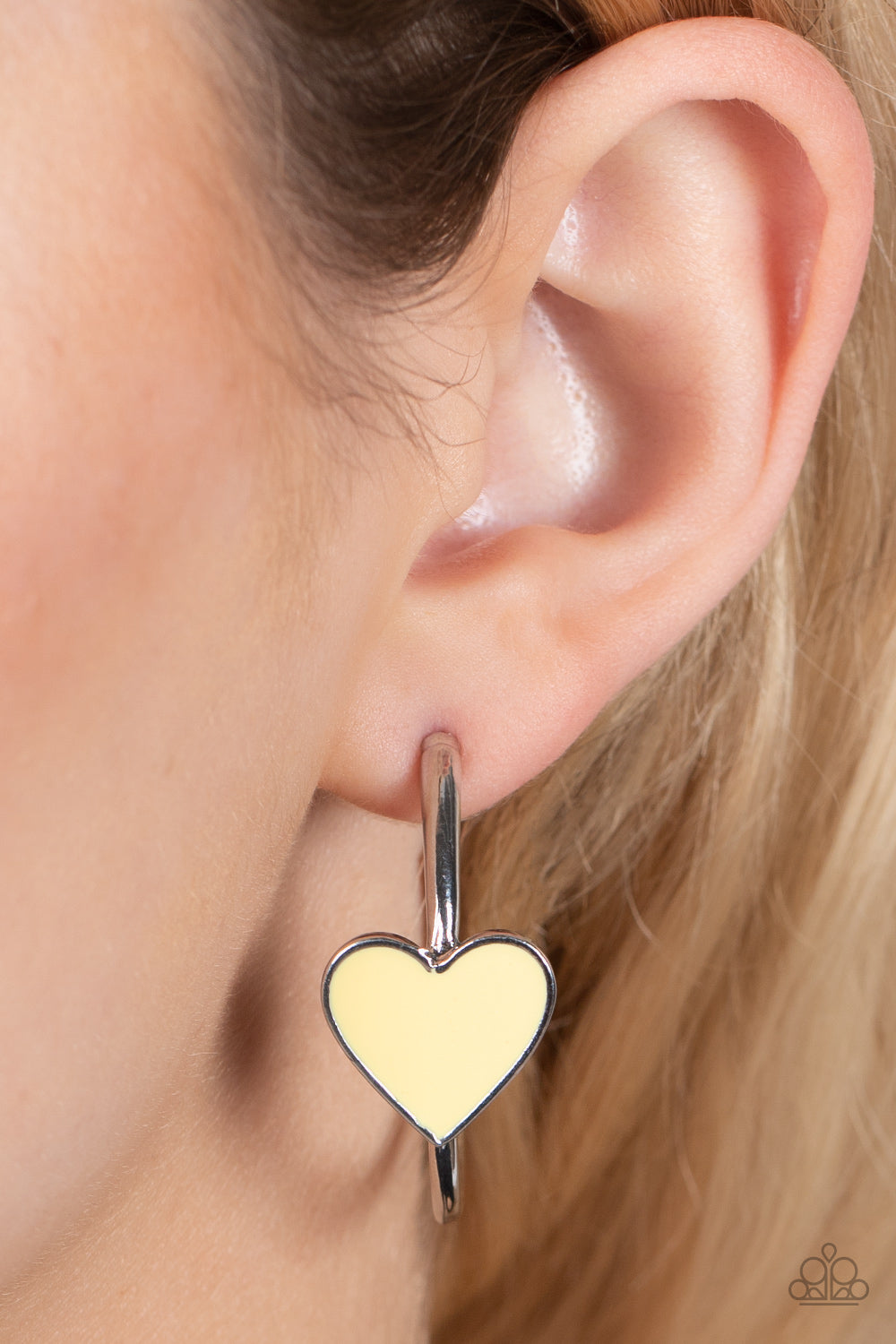 Kiss Up - Yellow Heart Hoop Earrings a charming Illuminating heart adorns the front of a classic silver hoop resulting in a whimsical fashion. Earring attaches to a standard post fitting. Hoop measures approximately 1 1/4" in diameter.  Sold as one pair of hoop earrings.  Paparazzi Jewelry is lead and nickel free so it's perfect for sensitive skin too!