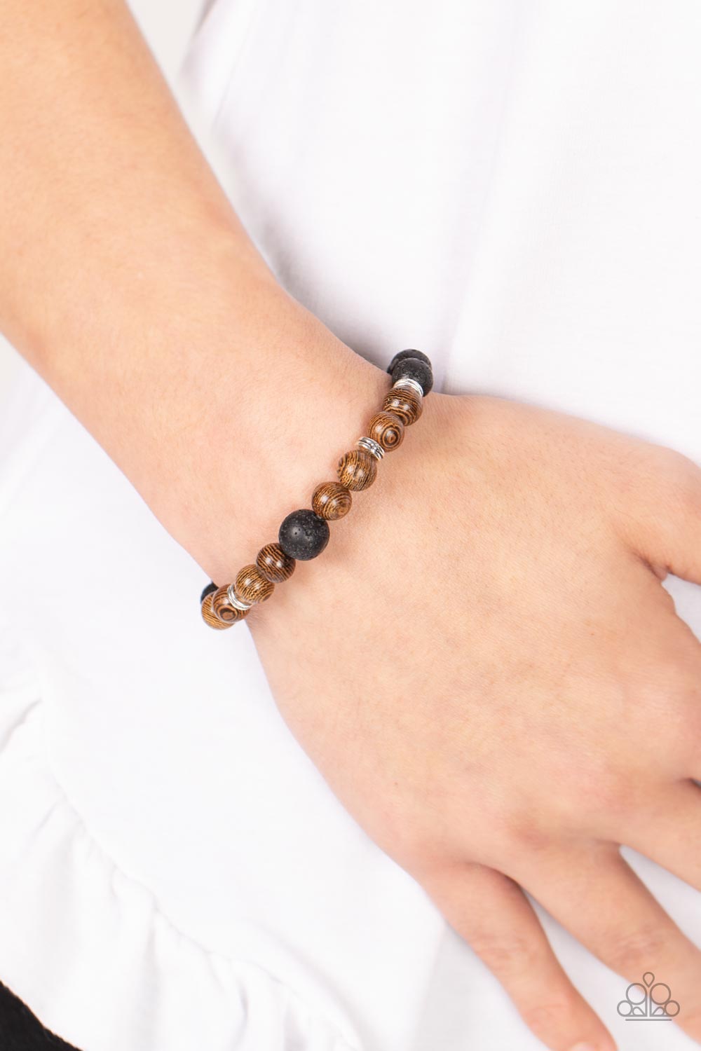 Paparazzi Neutral Zone - Brown Urban Bracelets infused with dainty silver accents, an earthy compilation of brown wooden beads and black lava stone beads are threaded along stretchy bands around the wrist for an urban flair.  Sold as one individual bracelet.