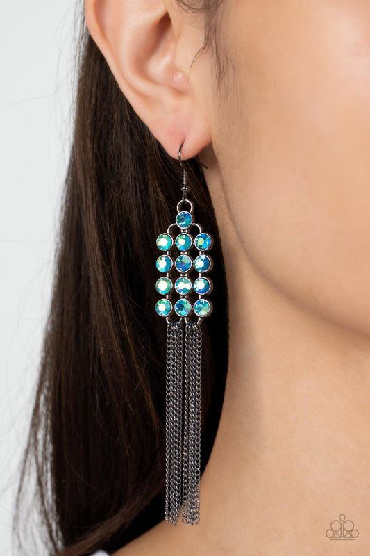 Tasteful Tassel - Multi Oil Spill Earrings encased in sleek hematite fittings, rows of glittery multi-colored oil spill rhinestones stack into a sparkly frame. Dainty gunmetal chains stream from the bottom of the dazzling frame, adding flirtatious movement to the timelessly tasseled display. Earring attaches to a standard fishhook fitting.  Sold as one pair of earrings.  Paparazzi Jewelry is lead and nickel free so it's perfect for sensitive skin too!