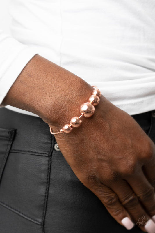 Paparazzi Accessories - Bead Creed - Copper Cuff Bracelets gradually increasing in size, an oversized collection of shiny copper beads are threaded along a dainty shiny copper cuff for a dramatic industrial display.  Sold as one individual bracelet.